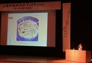 プロジェクターの内容を説明している様子(写真)