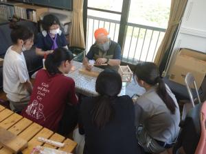 高校生が町内会の方からミニ行灯の作成の説明を受けている写真