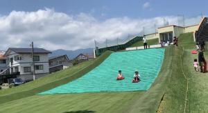 坂から滑り降りる子どもたち(写真)