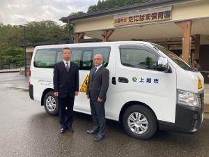 たにはま保育園に納車された新しい通園バスを視察するウチダ和漢薬浅間取締役工場長と松野製造業務課長(写真)