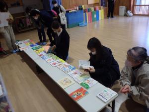 参考に置かれた絵本を見る参加者の写真