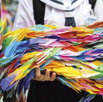 色とりどりの千羽鶴を抱えて持つ中学生（写真）