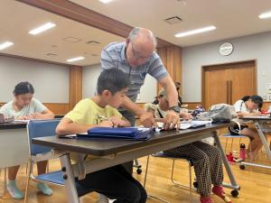 先生に教えてもらっている男の子の様子（写真）