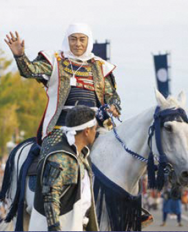 出陣行列で白馬に乗り手を振る謙信公役の松平健さん（写真）