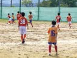 生徒たちがグラウンドで練習する様子（写真）