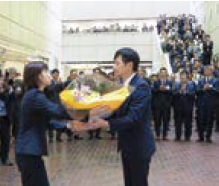 市役所木田庁舎1階ロビーで花束を受け取り、職員や来庁した市民に拍手で見送られる中川市長（写真）