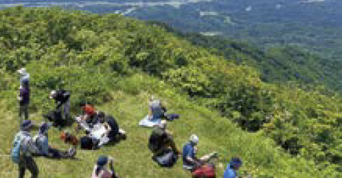 山頂でひと休みする参加者たち（写真）