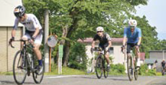 上り坂で自転車をこぐ選手たち(写真)