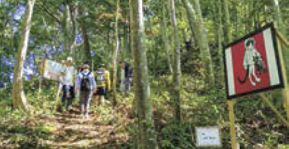山道に飾られた作品と登山者（写真）